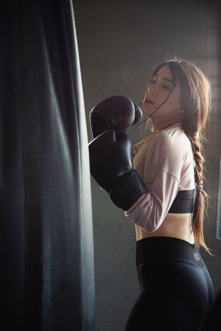 Woman training on a heavy bag inside a boxing gym